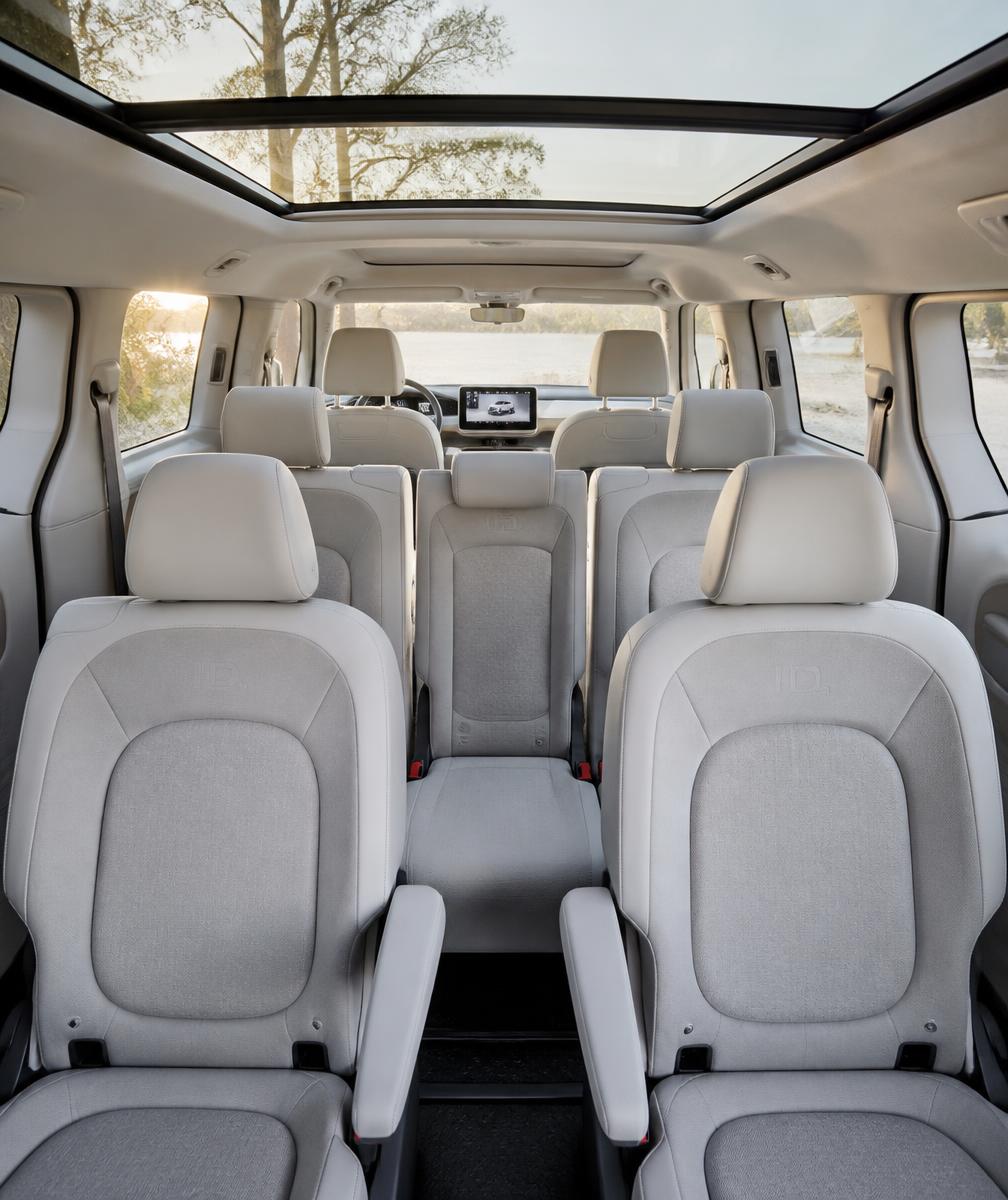 Interior de la Volkswagen ID Buzz con tres filas de asientos claros y techo panorámico